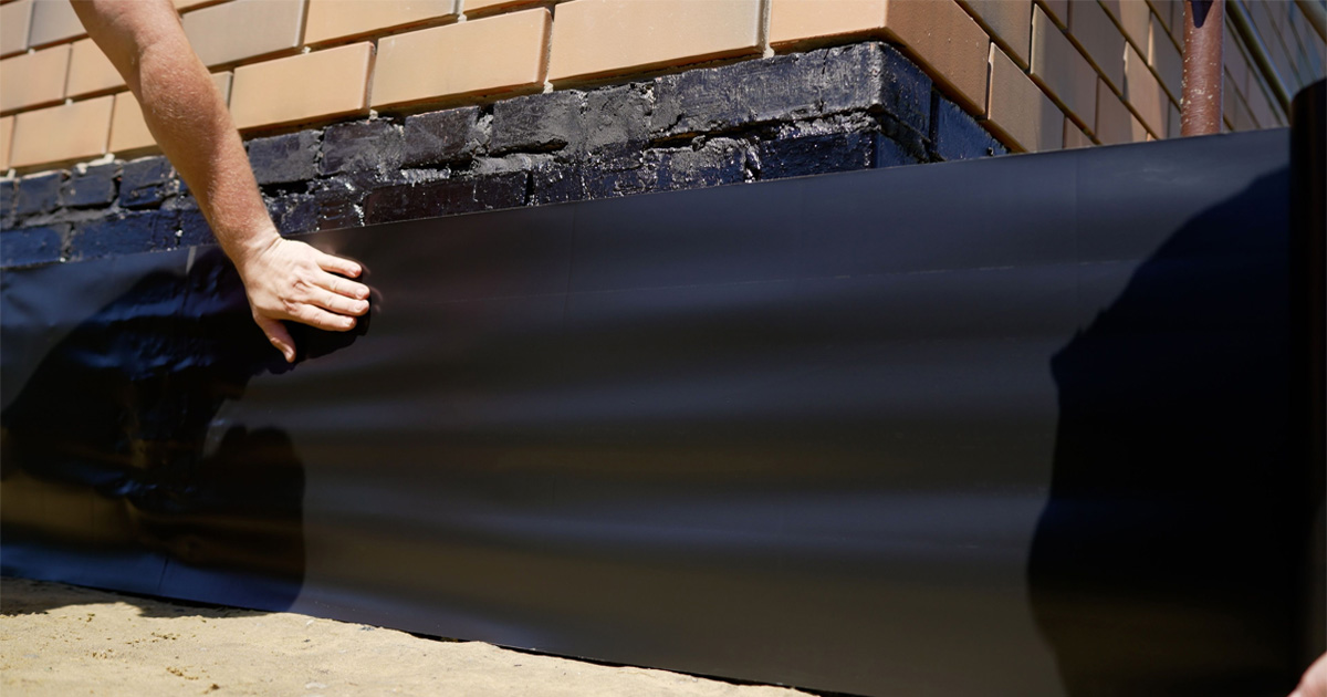 Waterproofing contractor in Brooklyn NY applying sealant to exterior brick wall